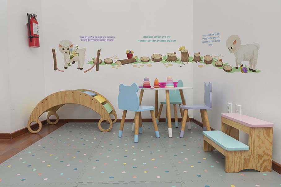 Children's play area in a pediatric office, with tables, chairs and games for children.